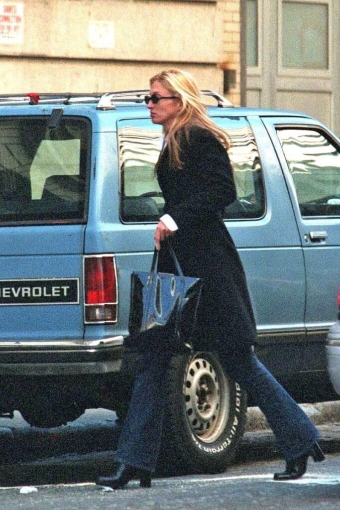Carolyn Bessette Kennedy out and about in New York,wearing black coat,blue denim and sunglasses.Paired with a Prada bag and black boots.