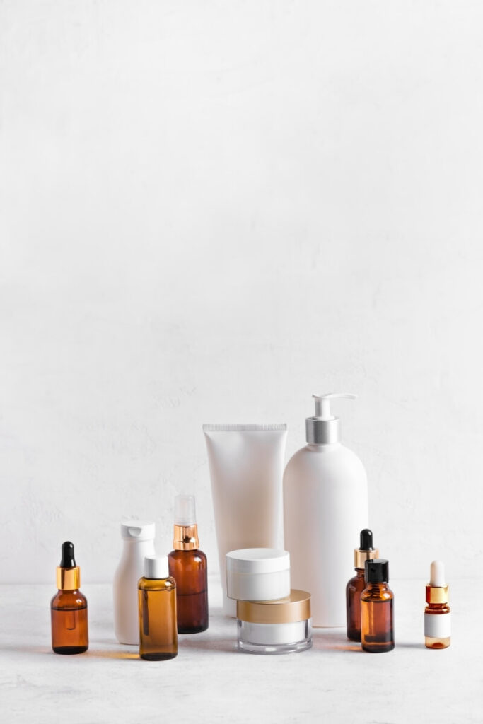 Korean skincare products arranged on a white surface including an essence, sheet mask, snail mucin serum and SPF for a glass skin routine