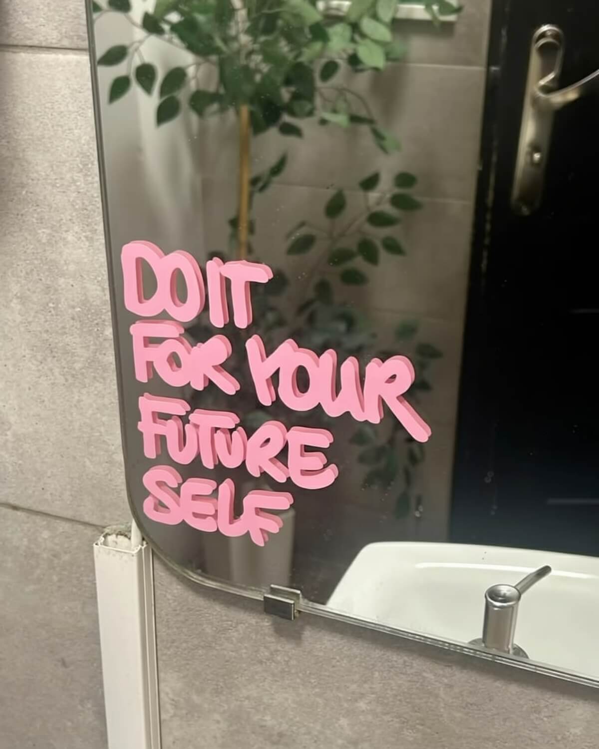 Pink letters on a bathroom mirror reading do it for your future self, a daily reminder to act from your future self identity